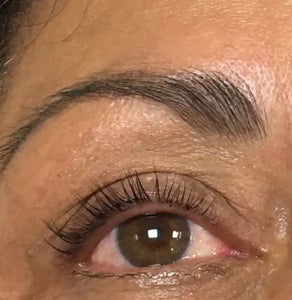Close-up van een vrouwelijk oog met volle wenkbrauw en lange donkere wimpers, schoonheid, huidverzorging
