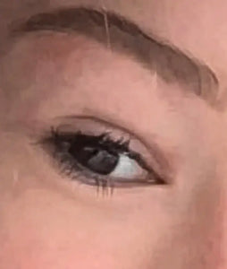 Close-up van een menselijk oog met natuurlijke wenkbrauw en lichte make-up