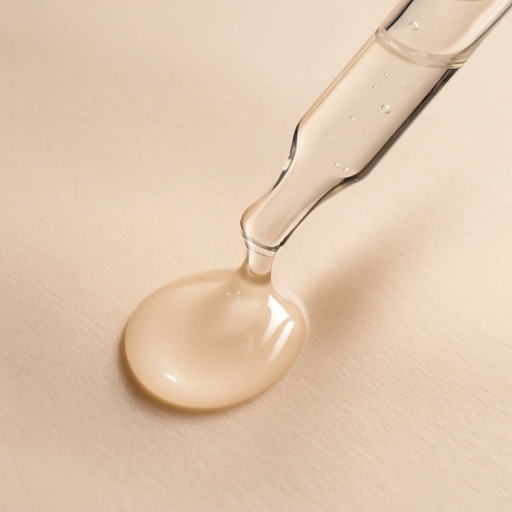 Close-up van pipet met transparant gezicht serum op een licht beige achtergrond